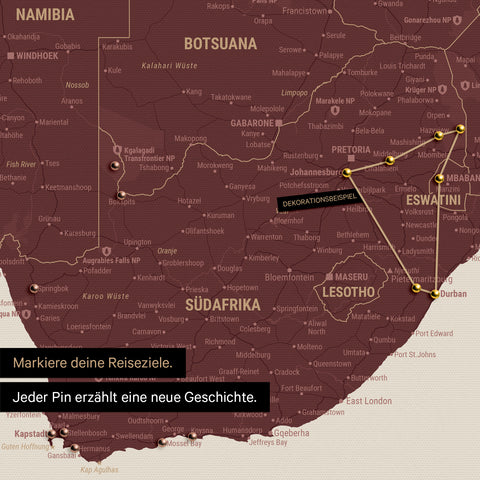 Detail einer Südafrika-Karte als Pinn-Leinwand in der Farbe Bordeaux-Rot mit Pins, die alle mit einem Garn verbunden sind und eine abgesteckte Reiseroute zeigen