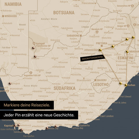 Detail einer Südafrika-Karte als Pinn-Leinwand in der Farbe Hale Navy (Dunkelblau-Gold) mit Pins, die alle mit einem Garn verbunden sind und eine abgesteckte Reiseroute zeigen