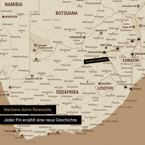 Detail einer Südafrika-Karte als Pinn-Leinwand in der Farbe Treasure Gold (Gold-Beige) mit Pins, die alle mit einem Garn verbunden sind und eine abgesteckte Reiseroute zeigen