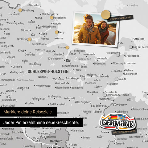 Detail einer magnetischen Deutschland-Karte als Magnettafel in Multicolor Gray zeigt Schleswig-Holstein mit einem angepinnten Urlaubsfoto sowie Reise- und Urlaubsmagnete