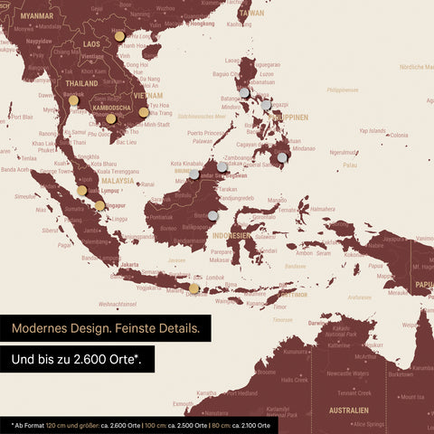 Ausschnitt einer magnetischen Weltkarte in Bordeaux Rot zeigt Karte von Asien, auf der Magnete Reiseziele markieren